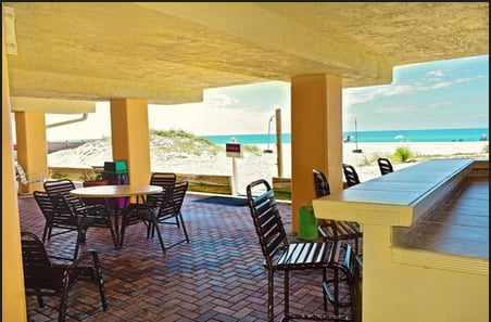 Our coverd lounge area with tables chairs and beach views.